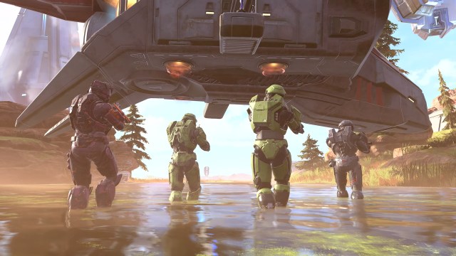 Quatro Spartans estão caminhando pela água em direção a um Covenant Phantom que está descendo para pousar em um planalto deserto.